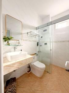 Un baño con inodoro, lavabo y ducha. en Bonnie Villa Beachside Mui Ne, en Mui Ne