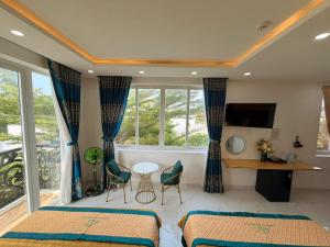 a hotel room with two beds and a balcony at Bonnie Villa Beachside Mui Ne in Mui Ne