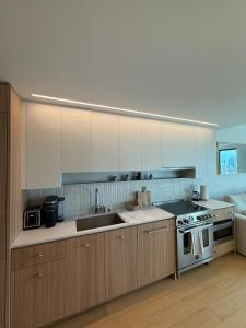 Una cocina con gabinetes blancos, un fregadero y una estufa. en Thrive Nest, en San Francisco