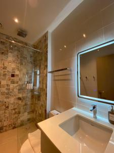 ein Badezimmer mit Waschbecken und Dusche mit Spiegel in der Unterkunft Swan, Private Pool Villa Bangsaen in Ban Thai Don (1)