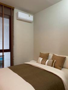 Ban Thai Don (1)にあるSwan, Private Pool Villa Bangsaenのベッドと窓のある寝室