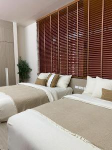 Ban Thai Don (1)にあるSwan, Private Pool Villa Bangsaenのベッドが2つと大きな窓がある部屋