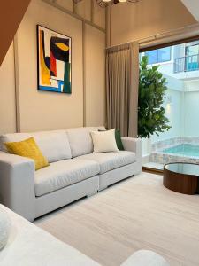 Ban Thai Don (1)にあるSwan, Private Pool Villa Bangsaenの白いソファとテーブルのあるリビングルーム +6枚の写真