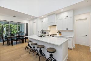 a kitchen with white cabinets and a kitchen island with stools at 132 Ocean Estates Dr in Lakewood Park