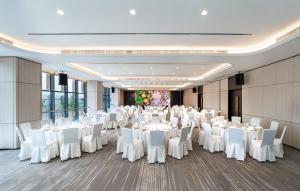 a banquet hall with white tables and white chairs at Holiday Inn Express Chongqing Liangjiang Yufu by IHG in Chongqing