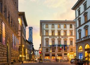 a city street with buildings and a clock tower at Helvetia&Bristol Firenze – Starhotels Collezione in Florence
