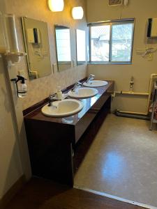 Un baño con tres lavabos y un espejo grande. en Suzuki Ryokan, en Noboribetsu 10 fotos más