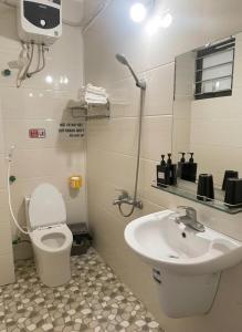 a bathroom with a toilet and a sink at Hana House in Kỳ Lừa