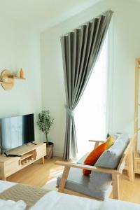 a living room with a bed and a window at Waveway bangsaen 1 in Ban Thai Don (2)