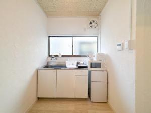 a small kitchen with a sink and a microwave at #39 Ukimafunado in Tokyo
