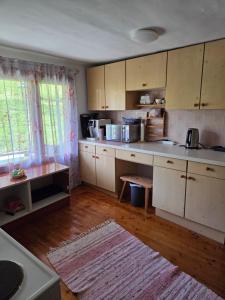 cocina con armarios blancos y suelo de madera en Natur- & Erlebnis Ferienhaus, en Voitsberg
