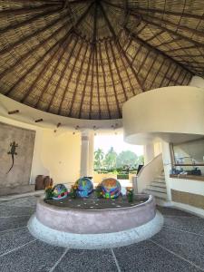 ein Gebäude mit einem runden Brunnen und einem Strohdach in der Unterkunft Frente al Mar totalmente remodelado para 6 personas in Ixtapa