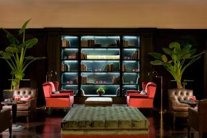 a living room with two chairs and a book shelf at Savoia Excelsior Palace Trieste - Starhotels Collezione in Trieste