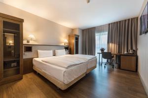 a hotel room with a large bed and a desk at Hotel CH Bucharest in Bucharest +67 photos