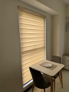 a table and chair in front of a window at Condo near Santa Rosa-Nuvali-Enchanted in Pulong Cacawate