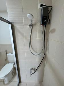 a shower in a bathroom with a toilet and a phone at Condo near Santa Rosa-Nuvali-Enchanted in Pulong Cacawate