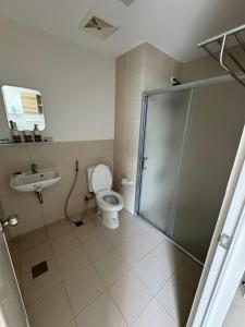 a bathroom with a shower and a toilet and a sink at Condo near Santa Rosa-Nuvali-Enchanted in Pulong Cacawate