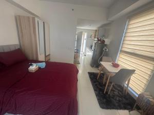 a bedroom with a bed and a table and a kitchen at Condo near Santa Rosa-Nuvali-Enchanted in Pulong Cacawate