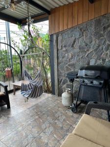 een terras met een grill en een hangmat bij Monteverde Guesthouse in Monteverde Costa Rica