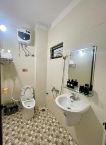 a bathroom with a sink and a toilet and a tv at Hana House in Kỳ Lừa