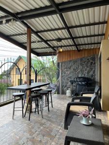 een patio met tafels en stoelen en een grill bij Monteverde Guesthouse in Monteverde Costa Rica