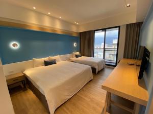a hotel room with two beds and a large window at Hai Sheng Wei B&B in Dahan