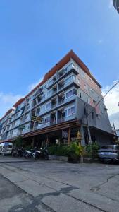 ein großes Gebäude mit davor geparkt in der Unterkunft Baan KetKaew GuestHouse 1 in Patong Beach