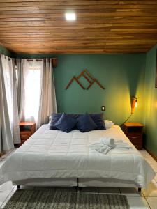 een slaapkamer met een groot bed met een houten plafond bij Monteverde Guesthouse in Monteverde Costa Rica