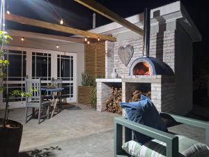 a patio with a brick oven with a table and chairs at 1 CAMDEBO in Oudtshoorn