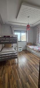 a room with two bunk beds and a wooden floor at appartement sable dor in Mohammedia +9 photos