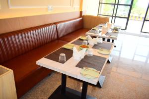 a row of tables in a restaurant with food on them at Radiant Sky Hotel in Kuchāman City