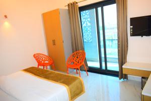 a room with a bed and two chairs and a window at Radiant Sky Hotel in Kuchāman City