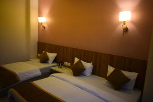 a hotel room with two beds and two lamps at Radiant Sky Hotel in Kuchāman City +25 photos