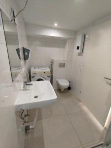 ein weißes Badezimmer mit Waschbecken und Toilette in der Unterkunft Mobilierte Monteuerswohnungen mit 2 Betten Stuttgart, Böblingen, Reutlingen, Waldenbuch - HeimbachEG in Waldenbuch