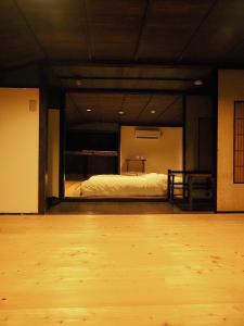 a room with a bed and a wooden floor at 萩市の静かな港町の一棟貸切宿 泊まれるカフェ 龍さん家 -Japanese traditional house- in Hagi