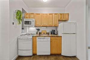 a kitchen with white appliances and wooden cabinets at Private Room at a Shared Apartment by Times Square Manhattan in New York