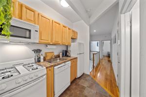 a kitchen with white appliances and wooden cabinets at Private Room at a Shared Apartment by Times Square Manhattan in New York