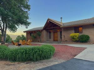 Una casa con una mesa y sillas delante de ella. en NEW LISTING, Near Yosemite South Gate entrance and town, King bed, Hot Tub, BBQ, Firepit & Mountain Views, en Oakhurst