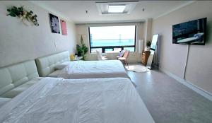 a bedroom with two beds and a view of the ocean at 스타샤인 in Busan