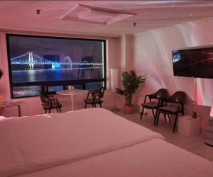 a bedroom with a large tv and a bed at 스타샤인 in Busan