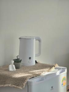 a white food processor sitting on top of a refrigerator at Waveway bangsaen 2 in Ban Thai Don (1)