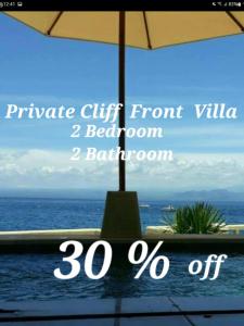 a view of the ocean from a balcony with an umbrella at Nusa Lembongan Villa Shambala in Nusa Lembongan