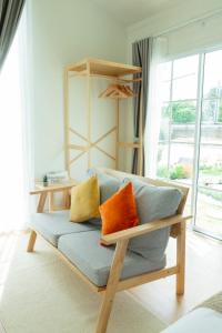 a couch with three pillows on it in a living room at Waveway bangsaen 2 in Ban Thai Don (1)