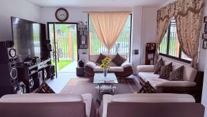 a living room with couches and a clock on the wall at Villa Mariaclaudia completa in Macas