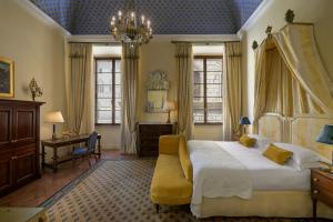 a bedroom with a bed and a desk and windows at Grand Hotel Continental Siena - Starhotels Collezione in Siena