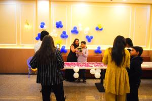 a group of people standing around a table with blue balloons at Radiant Sky Hotel in Kuchāman City