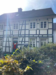 een wit en blauw huis met een stapel bloemen bij Ferienwohnung Altes Gut Kenkhausen in Wermelskirchen