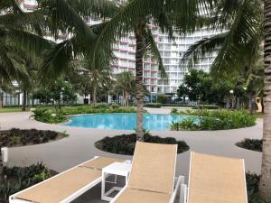 a resort with a pool and two chairs and a building at Cam Ranh Resort in Cam Ranh