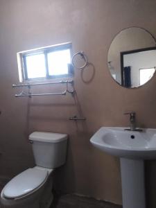 a bathroom with a toilet and a sink and a mirror at Hotel Don Abel Champotón in Champotón