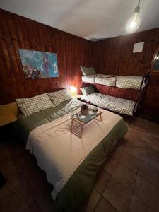 a bedroom with two beds and a table in it at Apartment surrounded by the peace of nature in Torgnon